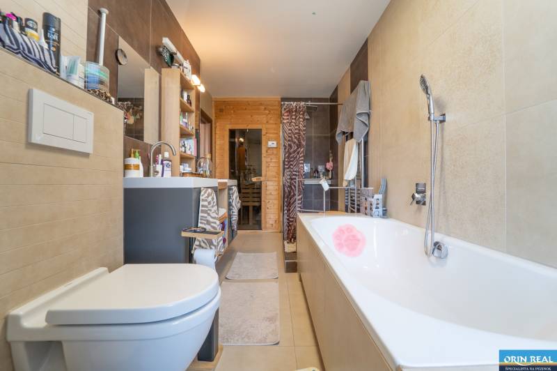 Bathroom in a family house with a shower, bathtub, and wooden decor.