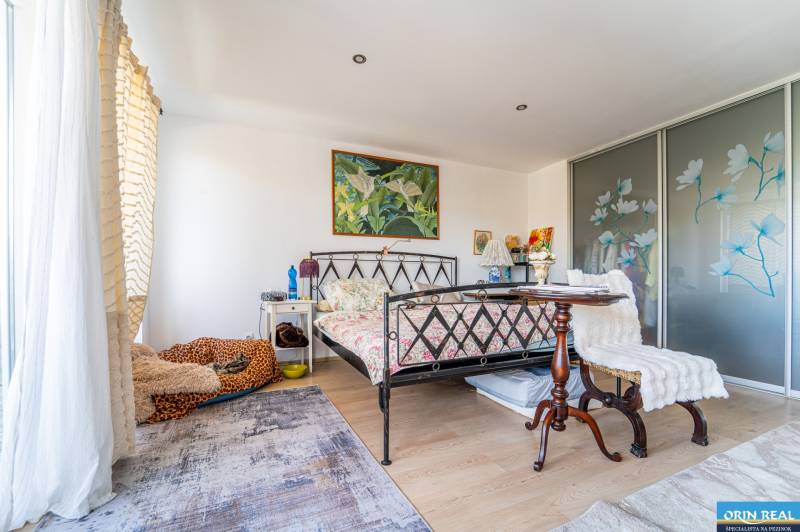 A bedroom in a family house with a bed, carpet, and sliding wardrobe.