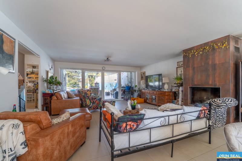 Living room in a family house with a fireplace and comfortable seating, floor with wooden decor.