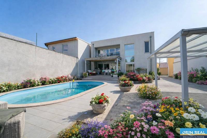 A family house on Bratislavská Street in Pezinok with a swimming pool and a flower garden.