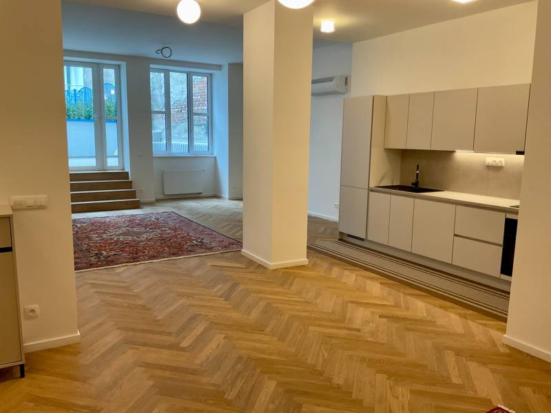 A kitchen corner with a wooden decor floor and stairs in a 2-room apartment.