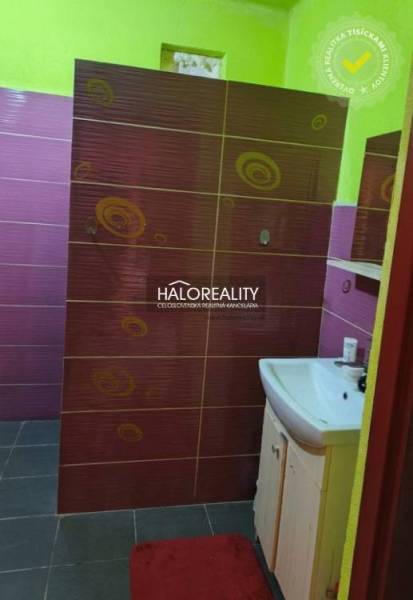 A colorful bathroom in a family house with a sink and tiles in contrasting colors.