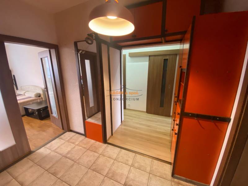 Hallway of a 3-room apartment with tiles, wardrobe closets, and passage to the bedroom.