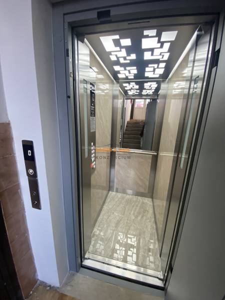 An elevator with a wooden decor floor in a 3-room apartment.