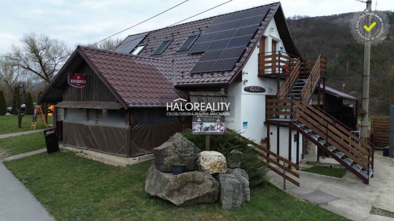 The exterior of the restaurant in Hnúšťa with wooden elements and solar panels on the roof.