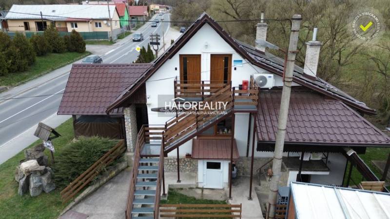 Gastro premises in Hnúšťa with an exterior staircase and a metal roof by the main road.