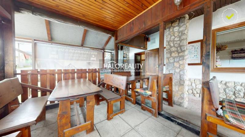 Wooden interior of a gastro space with stone, benches, and tables for guests.