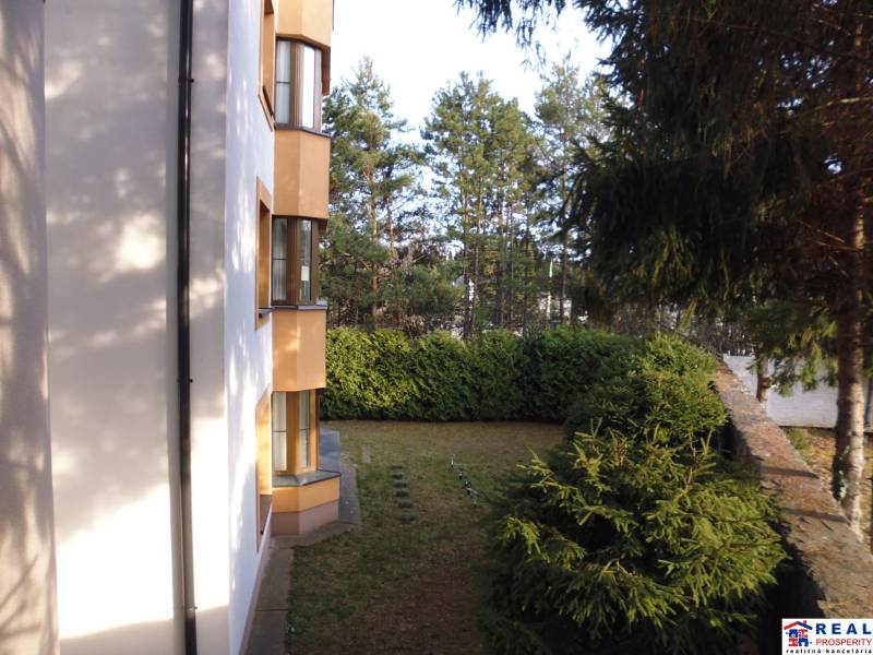 The exterior of the building on Vesela Street in Prešov, showing greenery and trees.