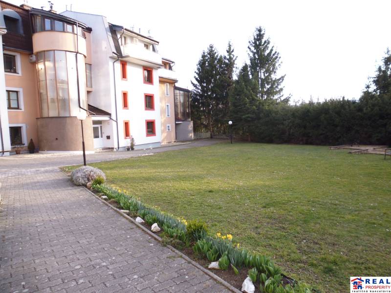 Exterior at an apartment building with a lawn and flowers on Veselá Street in Prešov.