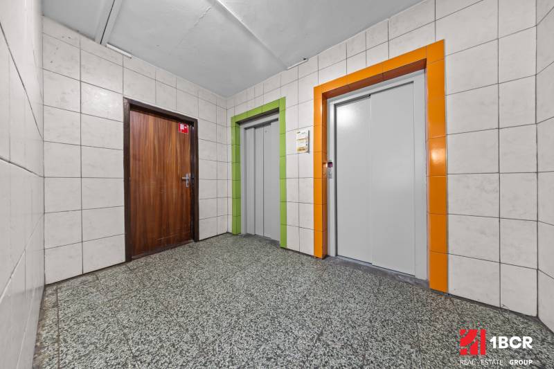 Hallway with entrance door and two elevators in a 3-room apartment.