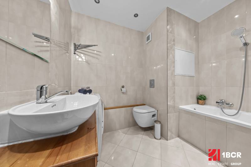 A bathroom with a bathtub, sink, and toilet in a 3-room apartment.