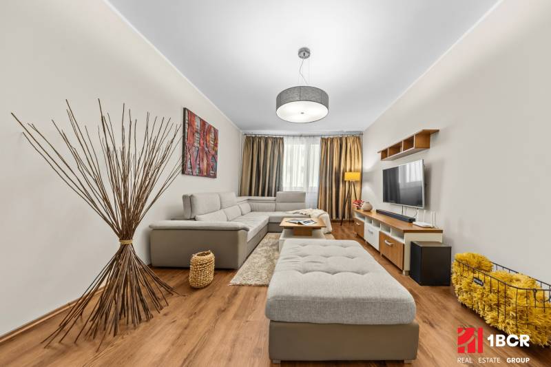 Living room in a 3-room apartment with a wooden decor floor and comfortable seating.