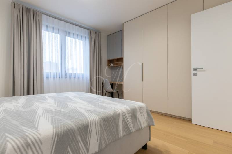 A bedroom with a bed, a wardrobe, and a wooden decor floor in a two-room apartment.