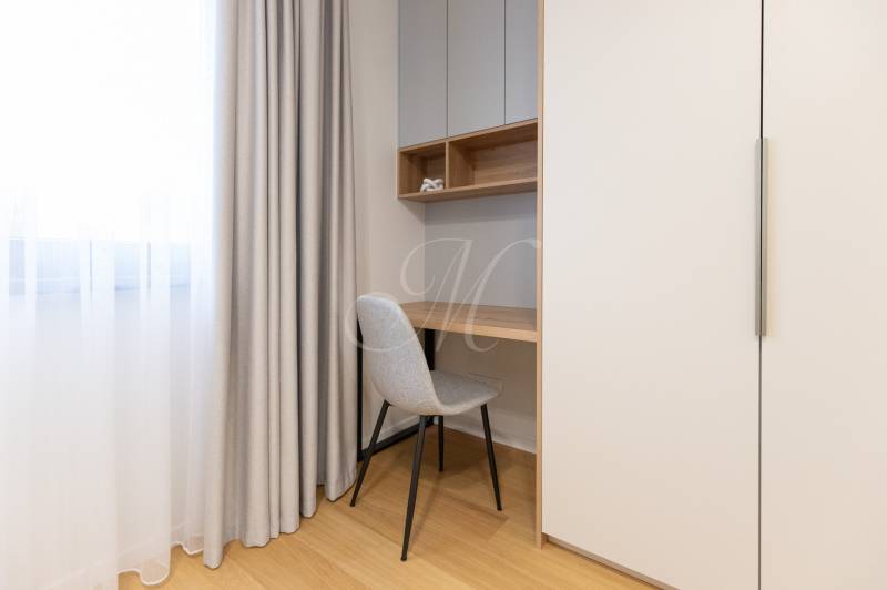 A workspace with a desk, chair, and cabinet in a 2-room apartment.