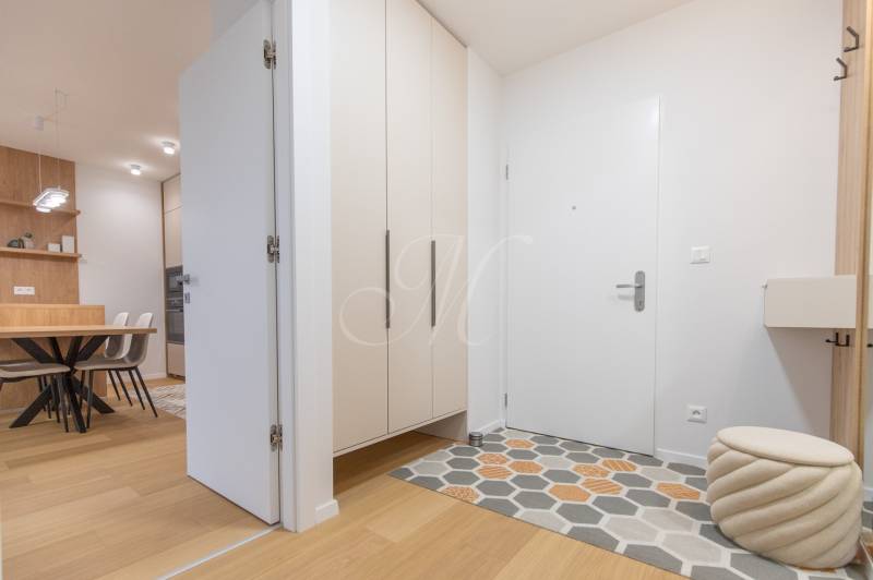Entrance hallway with wood-patterned flooring and modern furniture to a 2-room apartment.