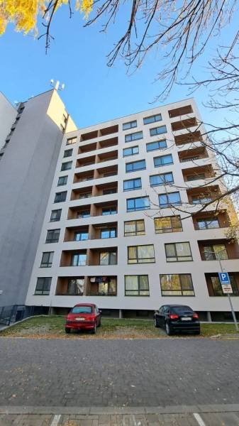 A ten-story building with balconies, parked cars in the city of Poprad.