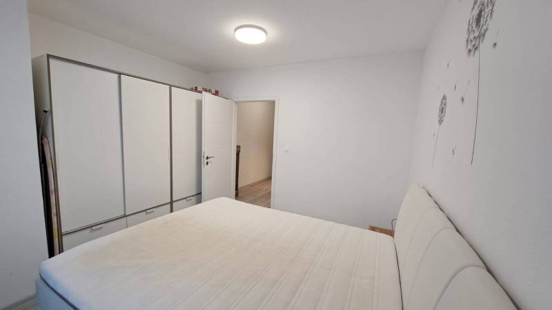 Bedroom in a family house with a white wardrobe and a bed.