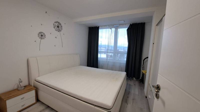Bedroom in a family house with white furniture and walls with dandelion motifs.