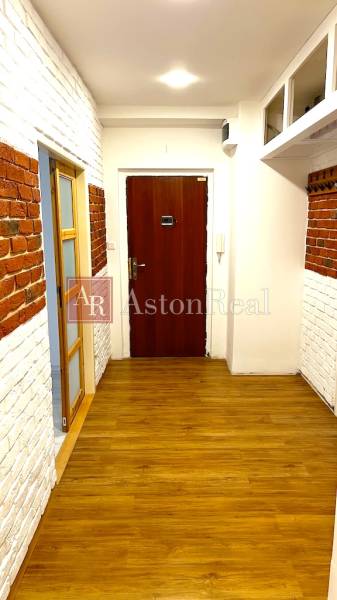 Entrance hallway with brick cladding and flooring with a wood decor in a 3-room apartment.