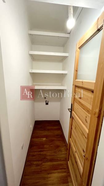A small room with a wooden decor floor and shelves in a 3-room apartment.