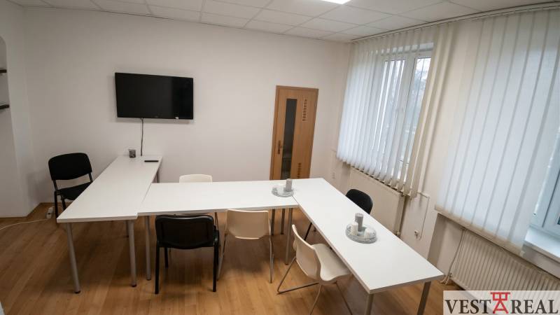 Offices with a conference table, chairs, television, and wood-patterned flooring.