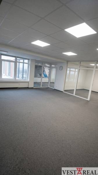 Open office space with glass partitions and carpet.