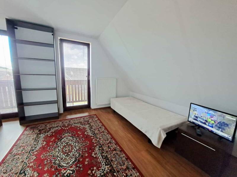 A room in a 3-room apartment with a wooden decor floor and a balcony.