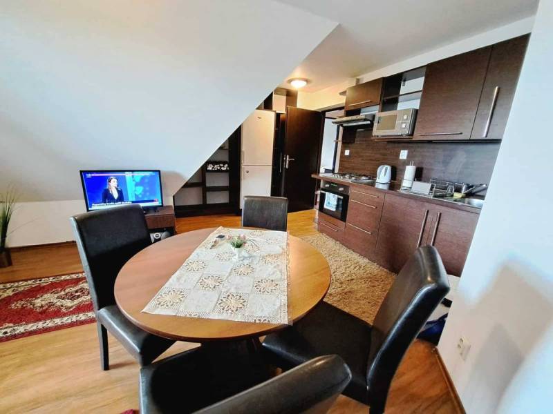 A kitchen in a 3-room apartment with a wooden decor and a dining table.