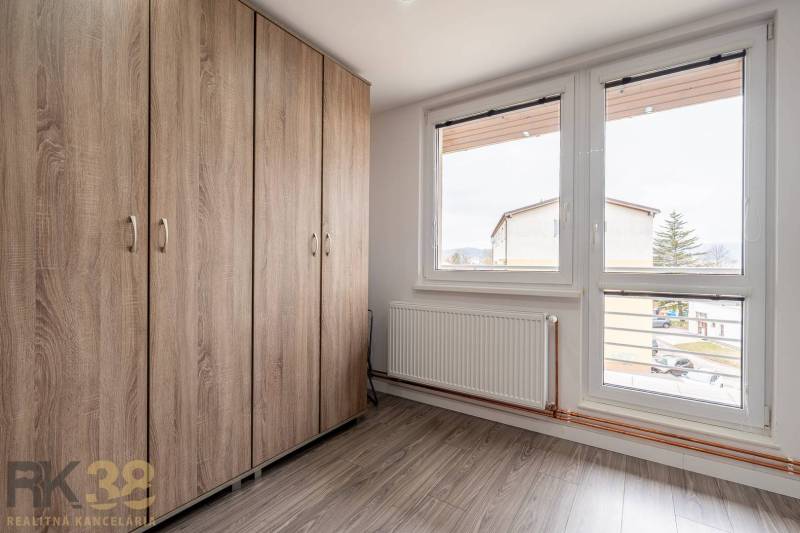 A wardrobe with a wooden decor and large windows in a 4-room apartment.
