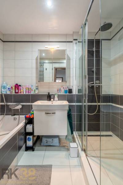 Bathroom in a 4-room apartment with a bathtub, shower, and modern sink.