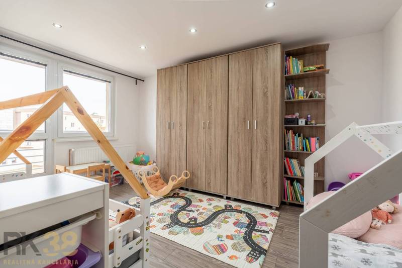 Children's room in a 4-room apartment with a decorative carpet and books.
