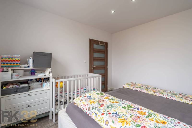 The children's room in the 4-room apartment contains a bed, a crib, and a changing table.