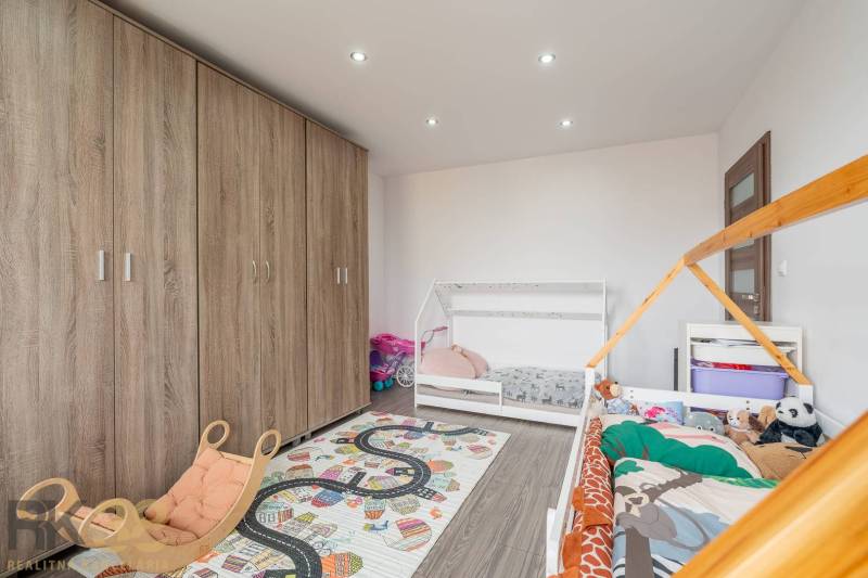 Children's room with beds, wooden decor flooring, and a large wardrobe in a 4-room apartment.