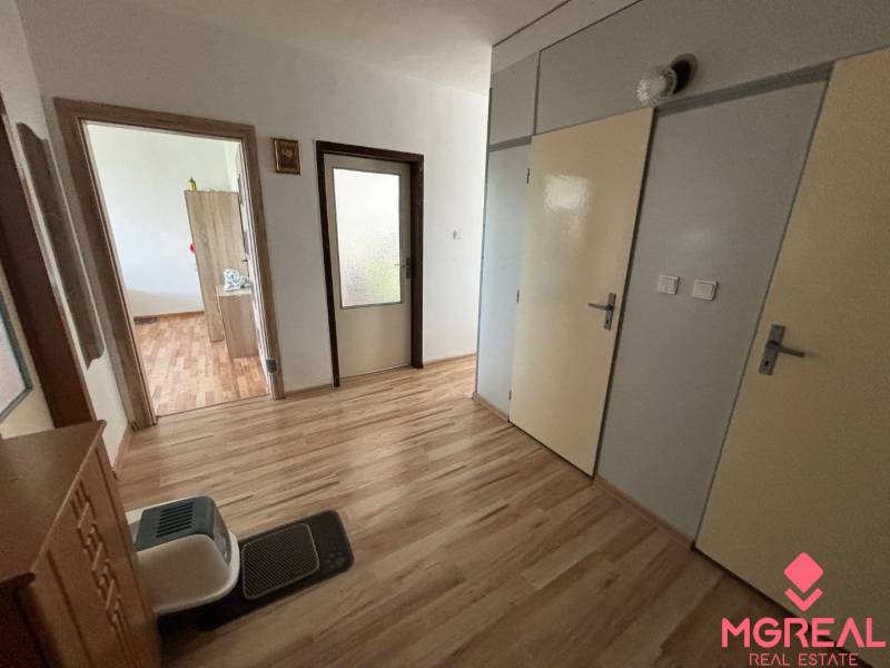Hallway in a 3-room apartment with a wooden decor floor and doors.