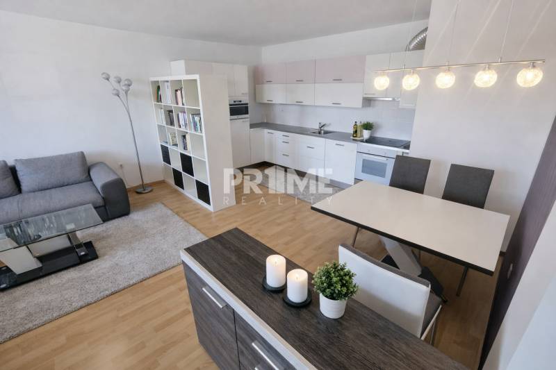 A kitchen with a sofa and a wooden decor floor in a 2-room apartment.