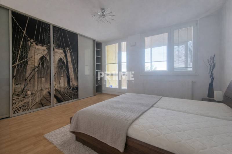 A bright bedroom with a large wardrobe and a wooden decor floor in a 2-room apartment.