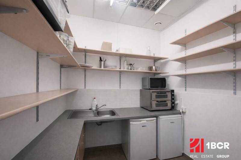 Kitchen corner with appliances and shelves in commercial premises.