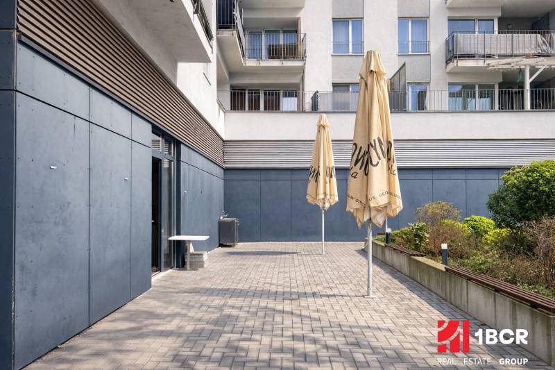 Terrace of commercial premises in Bratislava - Ružinov on Hrachova Street with paving and umbrellas.