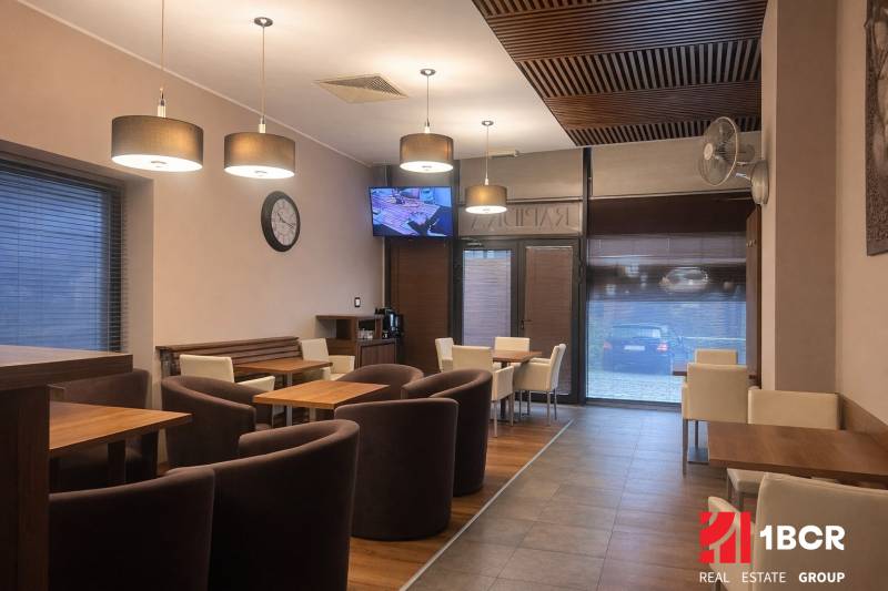 Interior of commercial spaces with wood-patterned flooring, chairs, and tables.