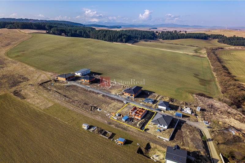 Houses under construction surrounded by fields and forests in Tvarožná.