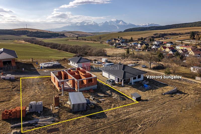 Construction of a family house in Tvarožná with a panorama of mountains behind the unfinished bungalow.