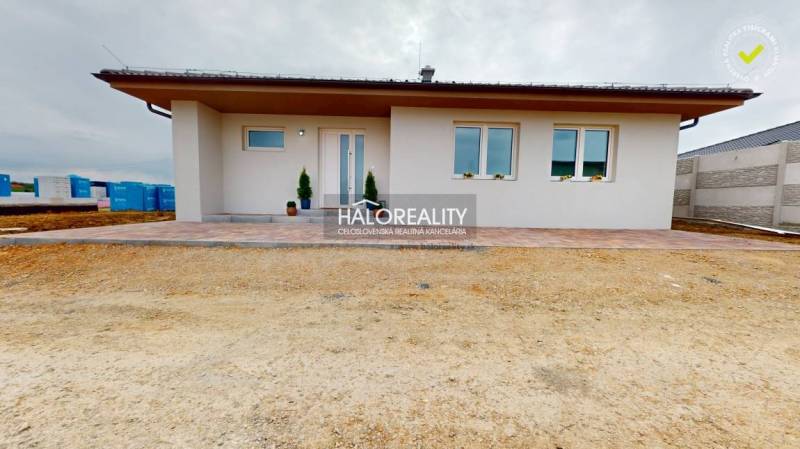 A family house in Rimavské Janovce with a white facade and a terrace in the front yard.