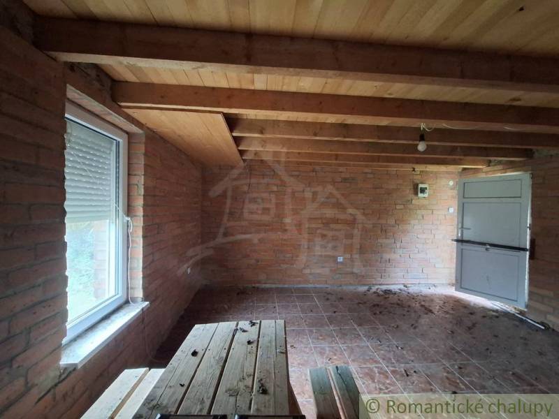Wooden ceiling and brick walls in the cabin, floor with wooden decor.