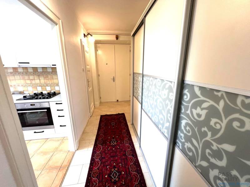 Hallway in a 2-room apartment with a kitchen, patterned carpet, built-in wardrobe.