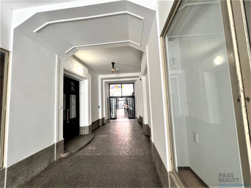 A hallway with vaulted ceilings, white walls, and doors in the background.