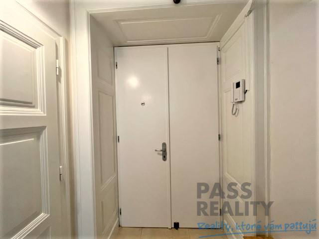 Entrance hallway with white doors and tiled floor in a 2-room apartment.