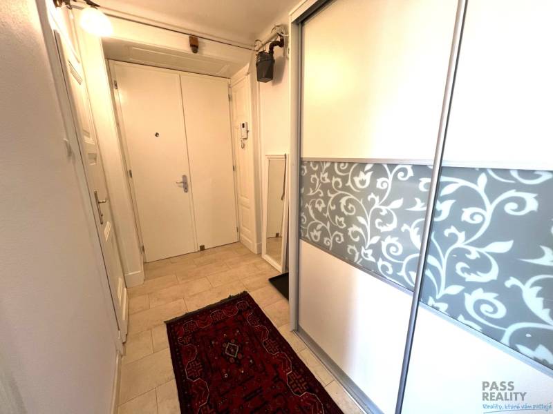 Entrance hallway of a 2-room apartment with a sliding wardrobe and a carpet.