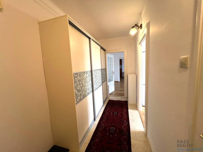 Hallway of a 2-room apartment with flooring, a wardrobe, and a carpet.