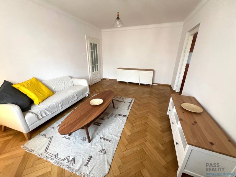 Living room with wood-patterned flooring, a sofa, and a wooden coffee table.
