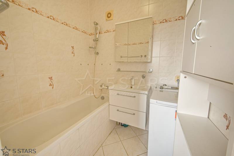 Bathroom in a 3-room apartment with a bathtub, mirror, and washing machine.
